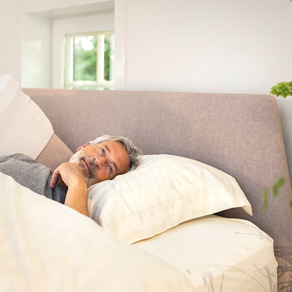 Ontspannen persoon wordt uitgerust wakker op een matras met slaapgarantie.