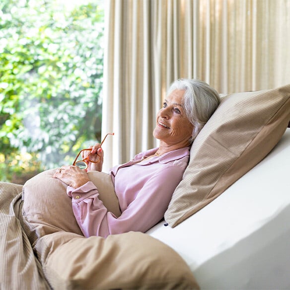 Wennen aan nieuw matras - oudere vrouw in bed